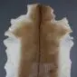 Natural goatskin rug with a dark brown dorsal stripe and light tan fur fading to cream edges.
