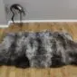 Triple rare breed sheepskin rug with long, textured wool in mottled grey, cream and charcoal tones.