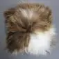 Square Icelandic sheepskin cushion with long, shaggy wool in spotted rusty brown and white tones.