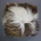 Square Icelandic sheepskin cushion with long, shaggy wool in a spotted rusty brown and cream pattern.