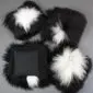 Four square Icelandic sheepskin cushions with long black and white spotted wool and a black fabric reverse.