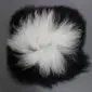 Square Icelandic sheepskin cushion with long, shaggy black and white wool.