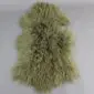 Khaki green Mongolian lambskin rug with long, curly wool fibres and an irregular natural shape.