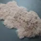 IMG_3533 Camel-coloured Mongolian lambskin rug with long, curly wool fibres and an irregular natural shape.