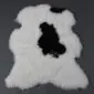 Shorn Icelandic sheepskin rug with white wool and a large central black patch.