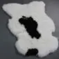 Shorn Icelandic sheepskin rug with natural white wool and large black markings in a unique organic shape. detail view