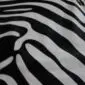 Close-up of a zebra print cowhide rug showing black and off-white stripes.