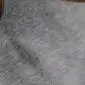 Close-up of a grey cowhide rug showing the natural hair texture and tonal variations. detail view