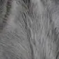 Close-up of a grey cowhide rug showing the natural hair texture and varying shades of silver and charcoal.