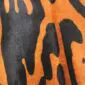 Close-up of jaguar print cowhide rug featuring black spots on an orange and tan background.