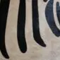 Close-up of a zebra print cowhide rug showing black stripes on a beige textured background.