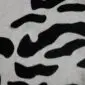 Close-up of a cowhide rug featuring a black and white tiger print pattern. detail view detail view