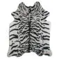 Natural cowhide rug with a black and white tiger print pattern and irregular edges.