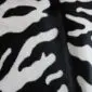 Close-up of a cowhide rug featuring a black and white tiger print pattern.