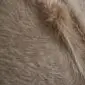Close-up of a beige cowhide rug showing the natural hair texture and light brown tones.