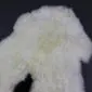Natural cream rare breed sheepskin rug with thick, curly wool pile and an organic shape.