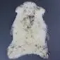 Natural cream rare breed sheepskin rug with grey and brown flecks and a long, textured wool pile.