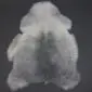 Shorn Icelandic sheepskin rug with natural grey and white mottled wool on a dark background.