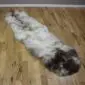 Long double sheepskin rug with natural cream, grey and dark brown mottled wool markings.