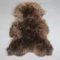 Natural brown rare breed sheepskin rug with thick, curly wool in variegated dark and light tones.