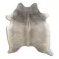Natural cowhide rug with a mottled tan and grey pattern and an irregular organic shape.