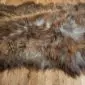 Large Icelandic sheepskin rug with long, thick wool in mottled rusty brown and grey tones.