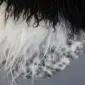 Close-up of a multi-layered sheepskin rug featuring long black, white and grey textured wool fibres.
