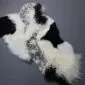 Large multi-layered designer sheepskin rug featuring textured patches of black, white, and grey patterned fur.