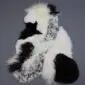 Large multi-layered sheepskin rug featuring irregular patches of cream, black, and grey patterned long-pile wool.