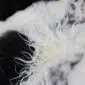 Close-up of a multi-layered sheepskin rug featuring long, textured white and black wool fibres.