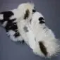 Large multi-layered sheepskin rug with long white wool and dark brown patches.