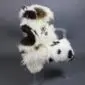 Large multi-layered sheepskin rug with long white wool and dark brown patches in an irregular natural shape.