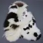 Large multi-layered sheepskin rug with irregular patches of white, cream, and dark brown long-pile wool.