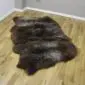 Large triple sheepskin rug with long, thick wool in mottled shades of dark brown and grey.