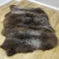 Large triple sheepskin rug with thick, textured wool in mottled shades of dark brown and grey.
