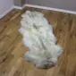 Long, double-length rare breed sheepskin rug with thick cream wool and natural grey markings.