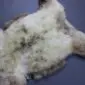 Natural rare breed sheepskin rug with thick cream and grey mottled wool in an organic shape.