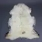 Natural cream rare breed sheepskin rug with grey and brown markings and thick, textured wool.