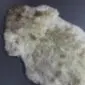Natural rare breed sheepskin rug with cream, grey and brown wool in an organic shape.